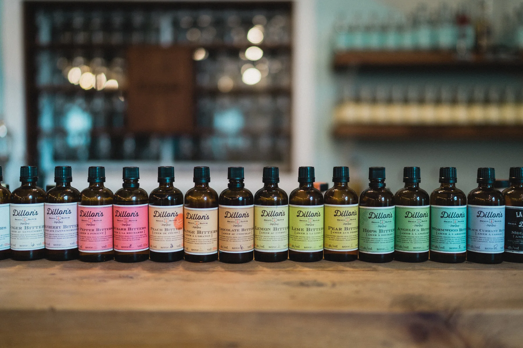 Colourful bitters bottles lined up on a wooden counter